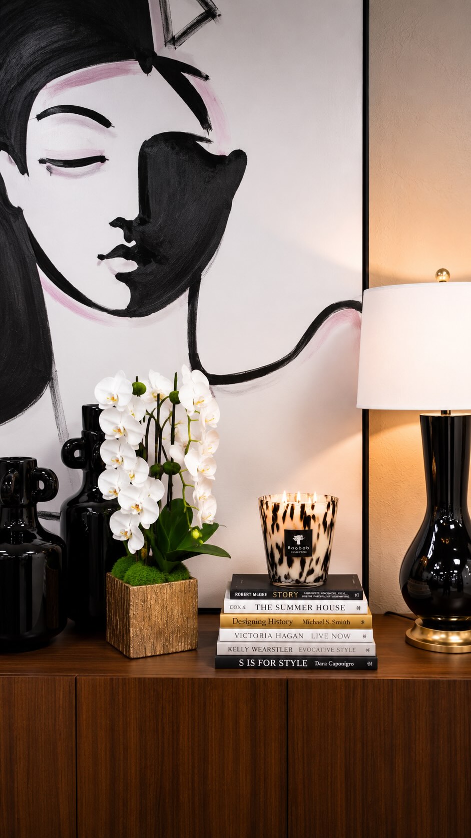 A beautifully designed room is never just about the furnishings. It’s the layering of accessories that creates warmth, refinement, balance, and soul. The finishing details are what transform a space from simply furnished to truly elevated. ✨Here are 3 styling principles we use regularly at IBB:1) ✨Permanent botanicals bring life, softness & movement.A room should always feel alive. Permanent florals and greenery introduce an organic element that softens hard surfaces, adds texture, and creates a sense of effortless elegance year-round. Whether it’s orchids, olive branches, or sculptural greenery, botanicals instantly make a space feel more polished and inviting.2) ✨Proper lamp scale changes the entire feel of a room.We typically recommend lamps that are 30” tall or taller. Taller lamps help extend the eye upward, creating better visual balance and giving a room a more sophisticated sense of scale. Lamps that are too short can unintentionally make a space feel visually heavy or compressed.3) ✨Generously scaled pillows create a more luxurious look.Undersized pillows are one of the quickest ways to diminish the overall feel of a room. We often use 22” pillows on sofas and accent chairs because they create fullness, softness, and a more tailored, designer-level finish.The magic of a room is almost always found in the layers. 🤍Save this for your next styling refresh & follow along for more beautifully layered interiors, thoughtful details, and design insights from #teamIBB.