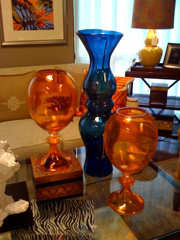 Colorful hand blown glass vases add drama to a rectangular glass cocktail table